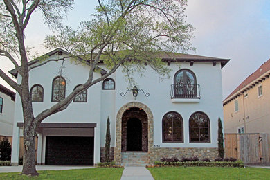 Large white two-story stucco exterior home idea in Houston with a hip roof