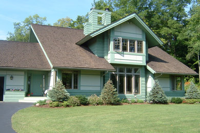 Imagen de fachada verde contemporánea de tamaño medio de dos plantas con tejado a dos aguas y revestimiento de madera