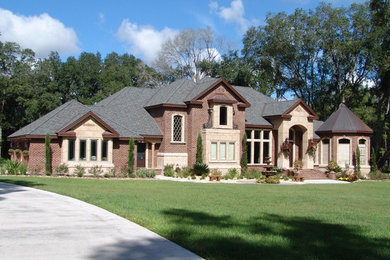 Large traditional brown two-story brick exterior home idea in Jacksonville