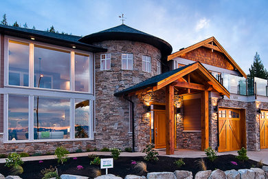 Photo of an expansive and brown rustic two floor house exterior in Toronto with stone cladding and a half-hip roof.