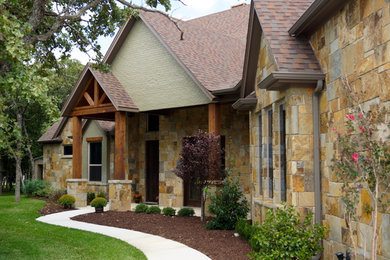 Inspiration for a mid-sized farmhouse green two-story stone gable roof remodel in Dallas