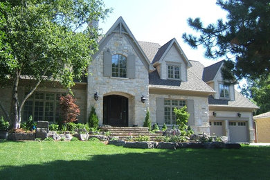 Пример оригинального дизайна: большой, двухэтажный, серый частный загородный дом в классическом стиле с облицовкой из камня, двускатной крышей и крышей из гибкой черепицы