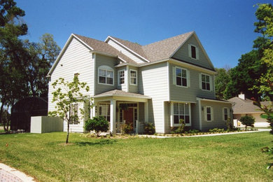 Foto de fachada de casa beige grande de dos plantas con revestimientos combinados, tejado a dos aguas y tejado de teja de madera
