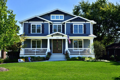 Modelo de fachada azul tradicional grande de dos plantas con revestimiento de vinilo y tejado a dos aguas