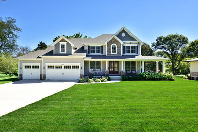 Inspiration for a large timeless beige two-story mixed siding exterior home remodel in Chicago with a clipped gable roof