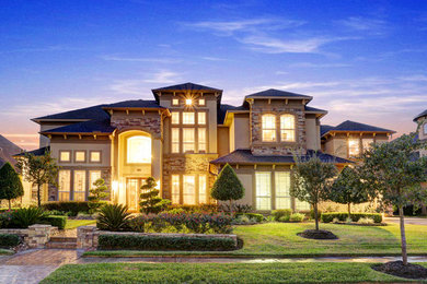 Huge traditional beige two-story exterior home idea in Houston
