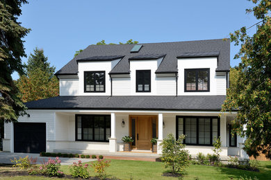 Ejemplo de fachada de casa blanca tradicional renovada de tamaño medio de dos plantas con revestimiento de madera, tejado a dos aguas y tejado de teja de madera