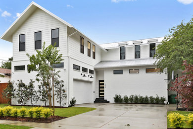 Ejemplo de fachada de casa blanca minimalista de dos plantas con revestimientos combinados, tejado a dos aguas y tejado de metal