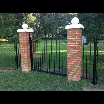 Custom transition piece between a chain link fence and a brick column.