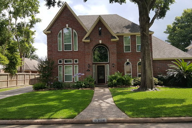 Inspiration for a timeless red two-story brick gable roof remodel in Houston