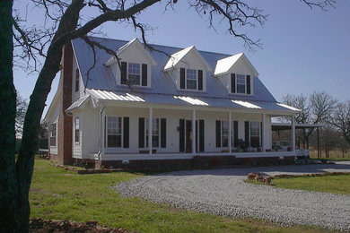 Imagen de fachada de casa de estilo de casa de campo de dos plantas con tejado a dos aguas y tejado de metal
