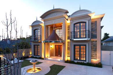 Cette image montre une très grande façade de maison beige en pierre à un étage.