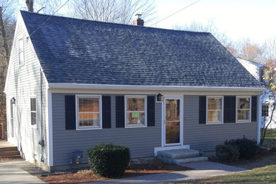 Diseño de fachada gris de estilo americano pequeña de dos plantas con revestimiento de madera y tejado a dos aguas
