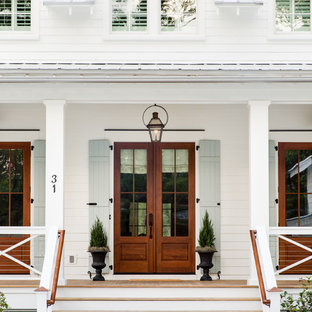 Example of a cottage white two-story wood exterior home design in Charleston with a metal roof