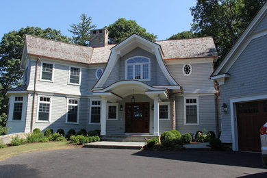 Imagen de fachada gris tradicional con revestimiento de madera y tejado a dos aguas