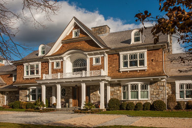 Cette image montre une grande façade de maison marron traditionnelle à deux étages et plus avec un revêtement mixte et un toit à deux pans.