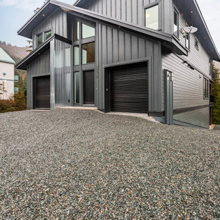 Foto på ett mycket stort funkis grått hus, med tre eller fler plan, blandad fasad, sadeltak och tak i metall