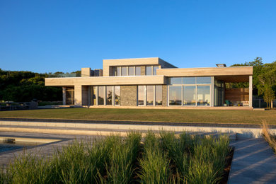Modelo de fachada de casa gris contemporánea extra grande de dos plantas con revestimientos combinados, tejado plano y tejado de teja de madera