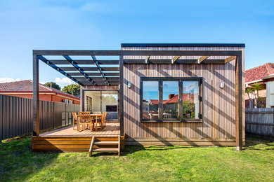 Modelo de fachada de casa marrón moderna de tamaño medio de una planta con revestimiento de madera, tejado plano y tejado de metal