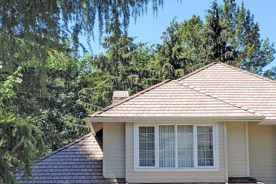 Mid-sized transitional beige two-story metal house exterior photo in Seattle with a hip roof and a shingle roof
