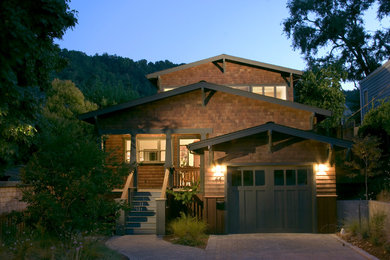 Diseño de fachada de casa marrón rústica grande a niveles con revestimientos combinados, tejado de teja de madera y tejado a dos aguas