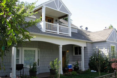 Ejemplo de fachada de casa gris clásica grande de dos plantas con revestimiento de madera, tejado a dos aguas y tejado de teja de madera