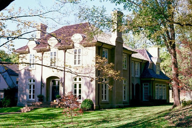 Inspiration for a mid-sized french country two-story stucco house exterior remodel in Other with a hip roof and a shingle roof