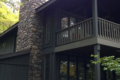 Inspiration for a mid-sized rustic gray two-story stone house exterior remodel in New York