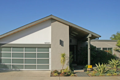Foto de fachada gris moderna de tamaño medio de una planta con revestimiento de estuco y tejado a dos aguas