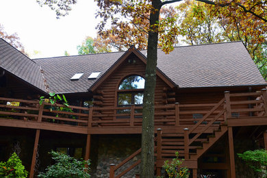 Inspiration for a mid-sized rustic brown two-story wood gable roof remodel in Milwaukee