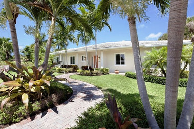 マイアミにある高級な中くらいなビーチスタイルのおしゃれな家の外観 (漆喰サイディング) の写真