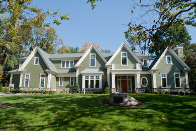 Example of a large classic green two-story vinyl gable roof design in New York