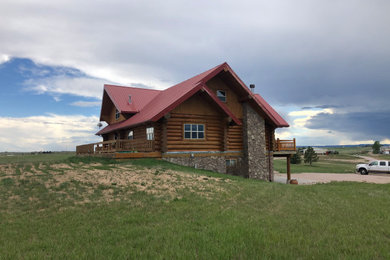 Ejemplo de fachada de casa beige y roja rural grande de dos plantas con revestimiento de madera, tejado a dos aguas, tejado de metal y panel y listón