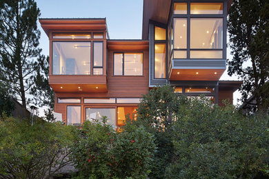Foto della facciata di una casa grande marrone contemporanea a due piani con rivestimento in legno e tetto piano