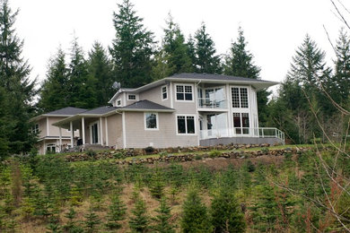 Ejemplo de fachada de casa beige actual grande de dos plantas con revestimiento de madera, tejado a la holandesa y tejado de teja de madera