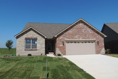 This is an example of a medium sized and red classic bungalow brick detached house in St Louis with a pitched roof and a shingle roof.