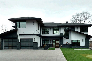 Пример оригинального дизайна: двухэтажный, белый дом среднего размера в современном стиле с комбинированной облицовкой и двускатной крышей