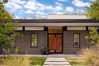 Photo of a gey modern bungalow house exterior in Austin with a flat roof.
