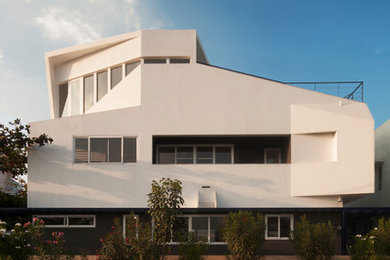 Diseño de fachada de casa multicolor actual de tres plantas con revestimiento de estuco y tejado plano