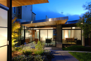 Ejemplo de fachada gris minimalista grande de tres plantas con revestimientos combinados y tejado de un solo tendido