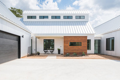 Modelo de fachada de casa contemporánea de tamaño medio de una planta con revestimientos combinados, tejado a dos aguas y tejado de metal