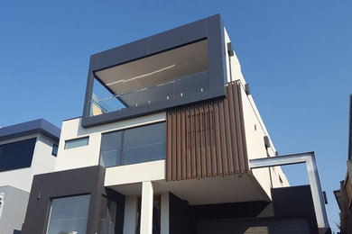Idées déco pour une grande façade de maison contemporaine à deux étages et plus avec un revêtement mixte, un toit plat et un toit en métal.