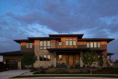 Contemporary three-story house exterior idea in Denver with a hip roof and a metal roof