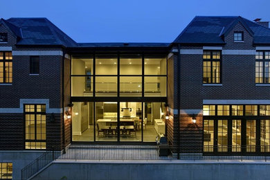 Imagen de fachada marrón minimalista grande de dos plantas con revestimiento de ladrillo y tejado a cuatro aguas