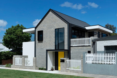 Foto de fachada de casa gris moderna pequeña de dos plantas con revestimiento de ladrillo, tejado a dos aguas y tejado de metal