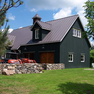 Lantlig inredning av ett svart trähus, med två våningar, sadeltak och tak i metall