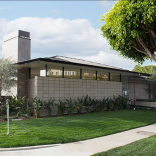 Inspiration for a 1950s gray one-story concrete house exterior remodel in Los Angeles with a hip roof and a metal roof