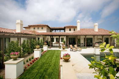 Inspiration for a mediterranean white split-level adobe exterior home remodel in Los Angeles