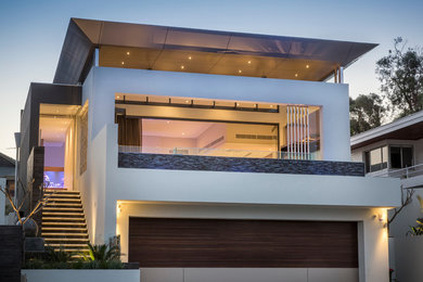 Diseño de fachada blanca actual grande de dos plantas con tejado plano y revestimientos combinados