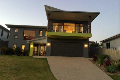 Diseño de fachada de casa multicolor moderna grande a niveles con revestimiento de hormigón, tejado a la holandesa y tejado de metal